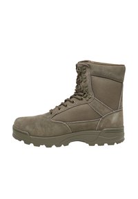 Bota de estilo militar en verde oliva oscuro, con parte superior de ante, puntera reforzada, paneles texturizados y suela de goma robusta con agarres.