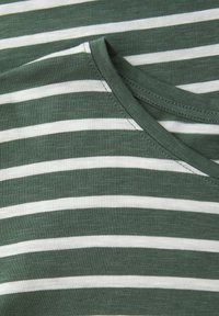 Primer plano de tela con rayas horizontales verdes y blancas, mostrando parte de un escote redondo con detalles de costura.