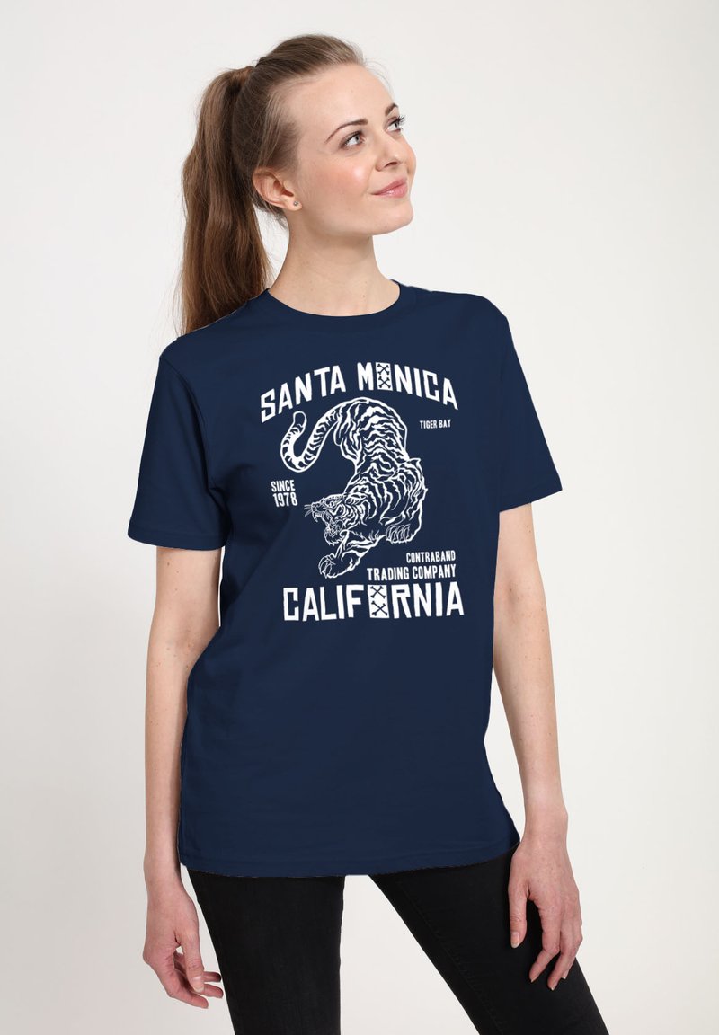 Námořnická modrá tričko s grafickým designem, který zobrazuje bílého tygra, text "Santa Monica" a "California", s uvolněným střihem a jemnou látkou.