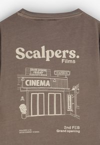 Brun bomulds t-shirt med hvid grafisk design af en biograf med teksten "Scalpers. Films", der viser billetbod og popcorn detaljer.