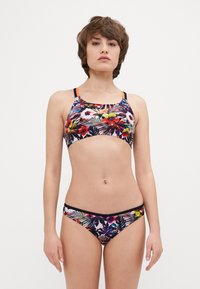 Ensemble de bikini à imprimé floral avec une base noire, des couleurs vives, des bretelles fines et des accents latéraux contrastants ; combine des motifs géométriques et tropicaux.