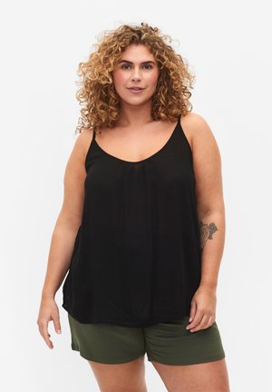 Top nero senza maniche con scollatura a V e dettagli arricciati, abbinato a pantaloni corti a coste verdi, morbido tessuto, design casual.