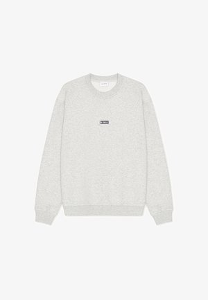 Lysegrå crewneck-sweatshirt med ribstrikkede manchetter og kant, med en lille rektangulær "LES DEUX" logo-patch placeret midt på brystet.