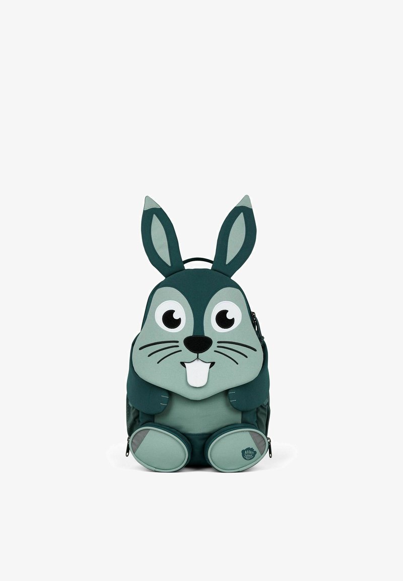 Grüner Stoffrucksack, der wie ein Hase gestaltet ist, mit langen Ohren, großen Augen, einer Schnauze und runden Füßen; enthält Reißverschlüsse und einen Griff.