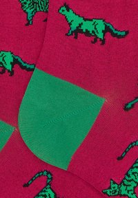 Calzini colorati con uno sfondo rosa e motivi animali verdi, con un polsino a contrasto verde. Realizzati in un materiale morbido e strutturato.