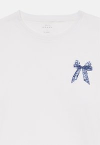 Balta crew neck marškinėliai su mažu mėlynu nėriniuotu kaspinu grafika viršutiniame kairiajame krūtinės kampe.