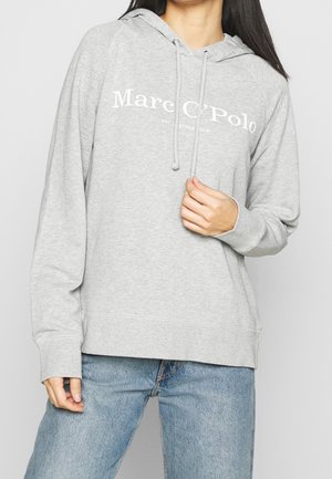 Grå hoodie i mjukt tyg med en kenguruficka. Har vit logotyptext och dragsnodd i huvan. Avslappnad passform med långa ärmar.