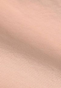 Tissu texturé de couleur pêche douce. Le matériau est lisse avec un motif côtelé subtil, créant une apparence douce et fluide.