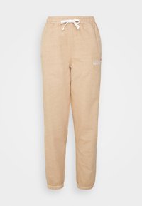 Beige joggers med elastisk midja, justerbar dragsko och ribbade ankle cuffs. Har en liten broderad logotyp på låret.