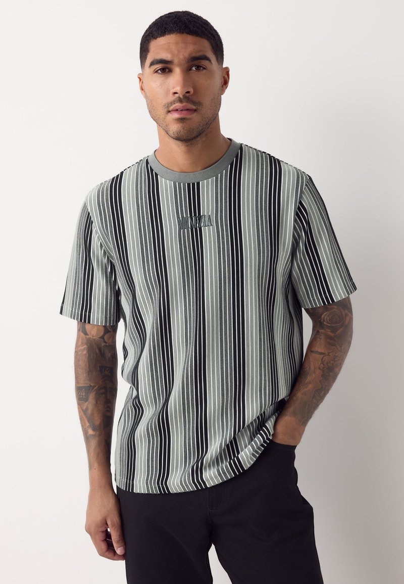 Gestreiftes Kurzarmshirt in Schwarz und Grau mit rundem Ausschnitt und eingesticktem Logo auf der Brust. Glatte Stoffstruktur.