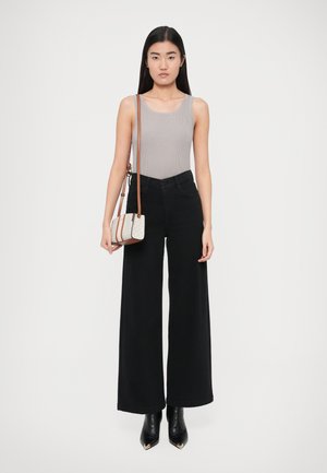 Szürke bordázott trikó, magas derekú fekete bőszárú nadrág, fekete hegyes végű bokacsizma és egy kis mintás válltáska barna részletekkel.