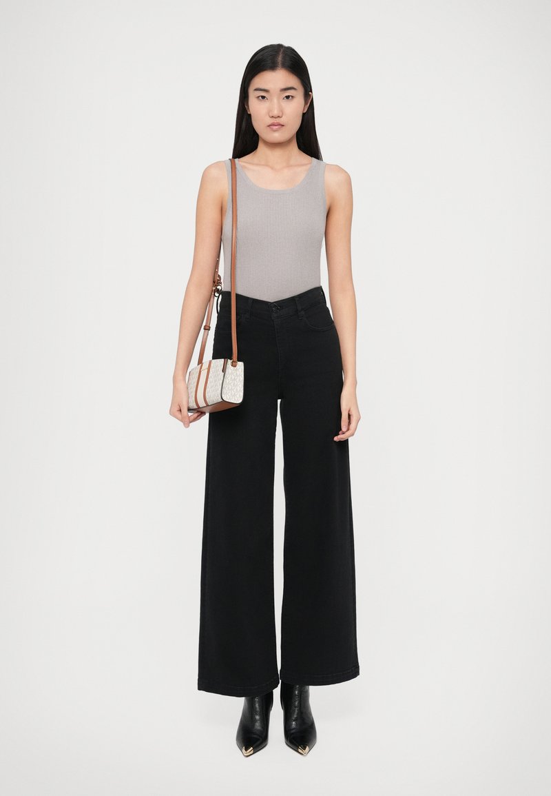 Hall halli ribakoot tankitopp, kõrge vöökohaga mustad laiade lahmakatega püksid, mustad teravnurkse ninaga pahkluu saapad ja väike musta mustriga õlakott pruunide detailidega.