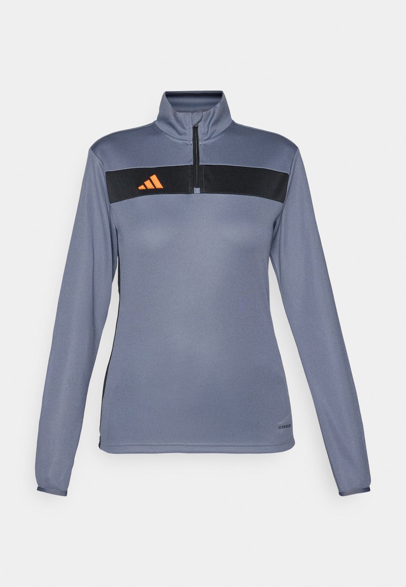Helles graues langärmliges Sportoberteil mit einem Halb-Reißverschluss-Kragen, das einen schwarzen horizontalen Streifen und ein oranges Logo auf der Brust aufweist. Glatte Stofftextur.
