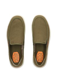Groene instap schoenen met een gestructureerde mesh bovenkant, witte zool en een oranje "HEY DUDE" logo. Voorzien van een gepolsterde inlegzool en elastische zijkanten.
