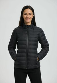 Sort puffjakke med høj krave, quiltet design, frontlynlås og sidelommer. Letvægtsmateriale med en glat tekstur.