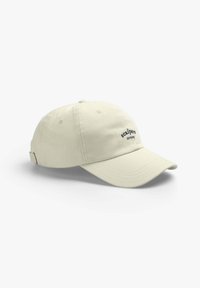 Beige baseball cap made of cotton with a curved brim, featuring a small embroidered logo on the front and an adjustable strap at the back.