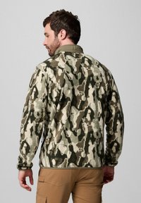 Tarnfleecejacke in Grün-, Beige- und Brauntönen. Mit einem Reißverschlusskragen, lockerer Passform und elastischen Bündchen. Glatte Textur.