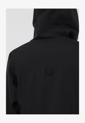 Giacca nera impermeabile con cappuccio, caratterizzata da una texture liscia e un dettaglio a loop sul retro, design minimalista e senza chiusure visibili.