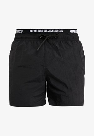 Black swim shorts made of lightweight fabric with a textured surface. Features an elastic waistband with a drawstring and branded logo.