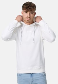 Hvid pullover hættetrøje lavet af en bomuldsblanding. Har en frontlomme, snoretræk til hætten med stribede detaljer og ribbede manchetter og kant.
