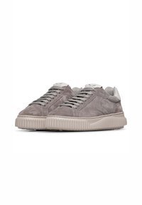 Baskets en daim gris avec une finition texturée, présentant une semelle de couleur crème et des lacets assortis, un design minimaliste et des détails de logo.