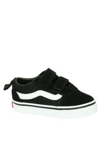 Deportiva negra con franja lateral blanca, que cuenta con dos correas de Velcro. La parte superior es de ante y tiene una suela de goma blanca con ribete negro.