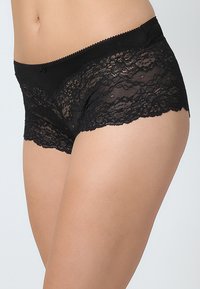 Sorte blonder boyshorts med en myk midjebånd og bølgete kanter, med en gjennomsiktig blonderstruktur og en tettsittende design.
