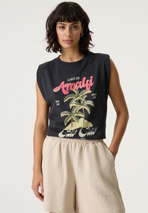 T-shirt noir sans manches avec un motif graphique représentant des palmiers et le texte "Amalfi." Associé à un short texturé de couleur beige clair.