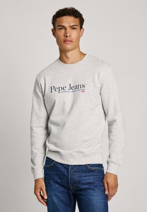 Sweat-shirt gris à col rond, fabriqué en tissu doux, portant le logo "Pepe Jeans" en bleu et rouge. Associé à un jean bleu. Texture lisse.