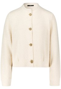 Cardigan corto color crema con texture a coste, con cinque bottoni dorati e tasche laterali. Scollo rotondo e maniche lunghe.