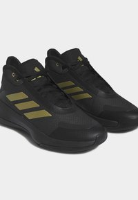Scarpe sportive nere con tomaia in rete, dettagli dorati, lacci piatti, suole imbottite e un design aerodinamico adatto per le attività sportive.