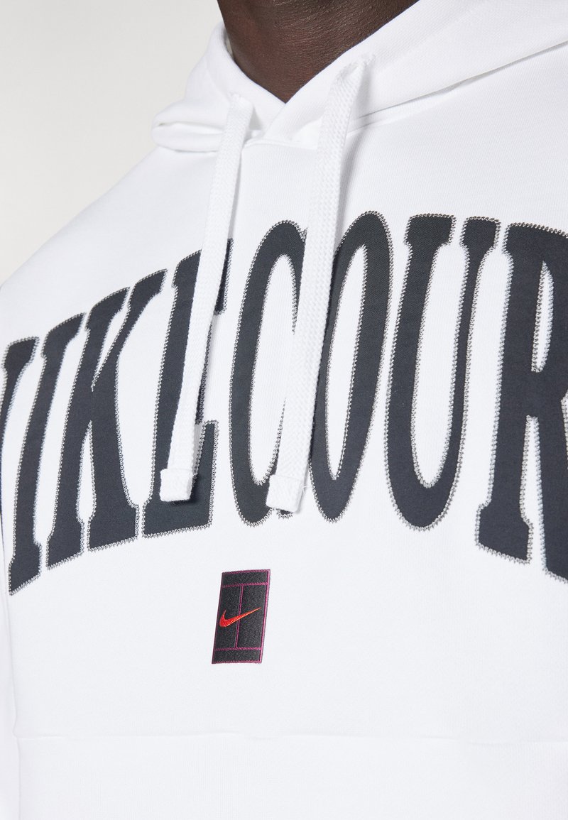 Sudadera blanca con texto negro "VIKLCOUR" y logo de Nike rojo. Presenta cordones y una textura suave. Diseñada para uso casual.