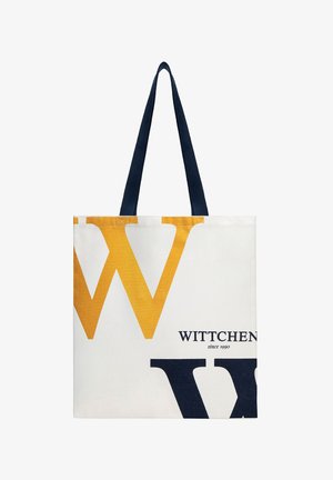 Bílá taška přes rameno s velkým žluto-černým písmenem "W" a černými držadly, na přední straně s nápisem "WITTCHEN since 1990".