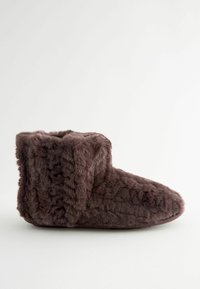 Stiefel aus Kunstfell in Dunkelbraun. Weicher, strukturierten Außenbereich mit umgeschlagenem oberen Rand. Abgerundete Zehenpartie und dezente Nähte. Flexibles Sohlen-Design.