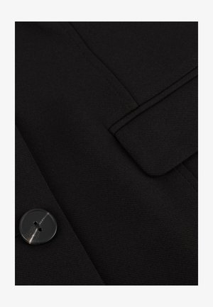 Zwarte wollen mix jas met een gladde textuur, strakke lijnen, een omgeslagen kraag en een ronde knoop met twee gaatjes als sluiting.