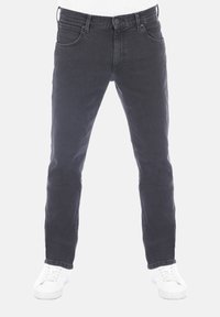 Jeans in denim nero con vestibilità slim, design a cinque tasche e passanti per cintura. Presentano una chiusura con bottone e zip, abbinati a sneakers bianche.