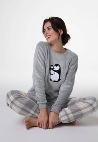 Felpa grigia in pile con ricamo di pinguino, abbinata a pantaloni pigiama a quadri grigi e bianchi. Tessuto liscio e vestibilità comoda.