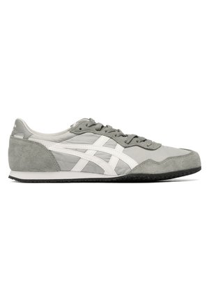 Grå og hvid lavtop-sneaker med ruskind detaljer, hvide sidelister, grå snørebånd og sort gummisål vist i profil.