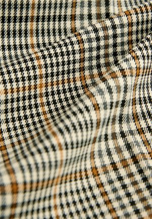 Tkanina s jemným vzorem v černobílé a oranžové barvě, která obsahuje detailní kostkované vzory a prvky houndstooth.
