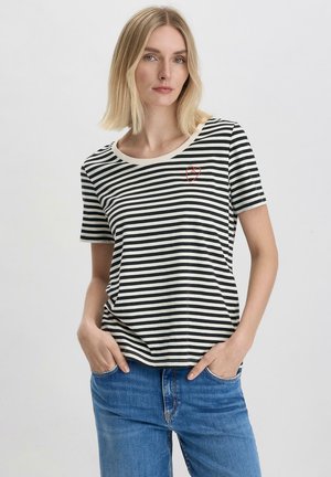 Gestreiftes T-Shirt mit schwarzen und cremefarbenen horizontalen Streifen, rundem Ausschnitt und kleinem roten Herzdetail auf der linken Brustseite, aus weichem Baumwollstoff.