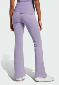 Fialové rozšírené nohavice vyrobené z mäkkej tkaniny s hladkým povrchom; majú vysoký pás a priliehavý strih s jemným leskom.