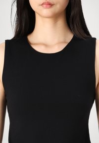 Black sleeveless top with a rounded neckline. Made from smooth, stretch fabric, featuring clean lines and a fitted silhouette.