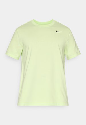 Limegrønn t-skjorte laget av bomull med korte ermer, rund hals og en svart Nike-logo på øvre venstre bryst. Glatt tekstur.