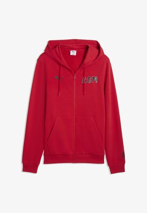 Rdeča jopa z zadrgo iz mehke tkanine. Ima kengurujski žep, črn napis "ACM" na sprednji strani in logotip na rokavu.