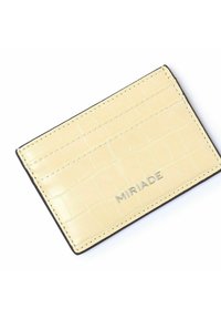 Żółty portfel na karty z faux skóry o fakturze węża krokodyla, czarnym przeszyciem i metalowym logo "MIRIADA" na dole.