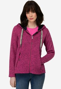 Fleece zip hoodie i stark rosa med en texturerad mönster, svarta detaljer på huven och justerbara dragskor. Har två sidofickor med dragkedja.