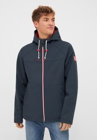 Navy waterproof jacket with a zip front and hood. Features contrasting red accents on the zipper and drawstrings, and two side pockets.