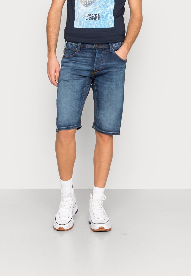 Denim shorts vaaleansinisessä värissä, rento malli, risat helmat ja viisi taskua. Yhdistettynä valkoisiin korkeisiin tennareihin ja sukkiin.