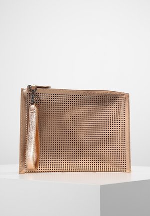 Pochette rectangulaire métallique en or rose avec un motif en grille, une lanière de poignet et une fermeture éclair sur le dessus, placée sur un piédestal blanc.