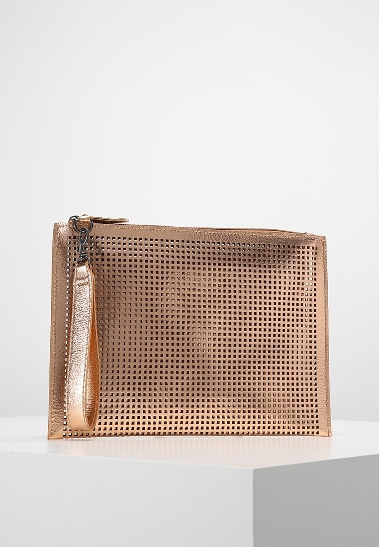 Pochette rectangulaire métallique en or rose avec un motif en grille, une lanière de poignet et une fermeture éclair sur le dessus, placée sur un piédestal blanc.